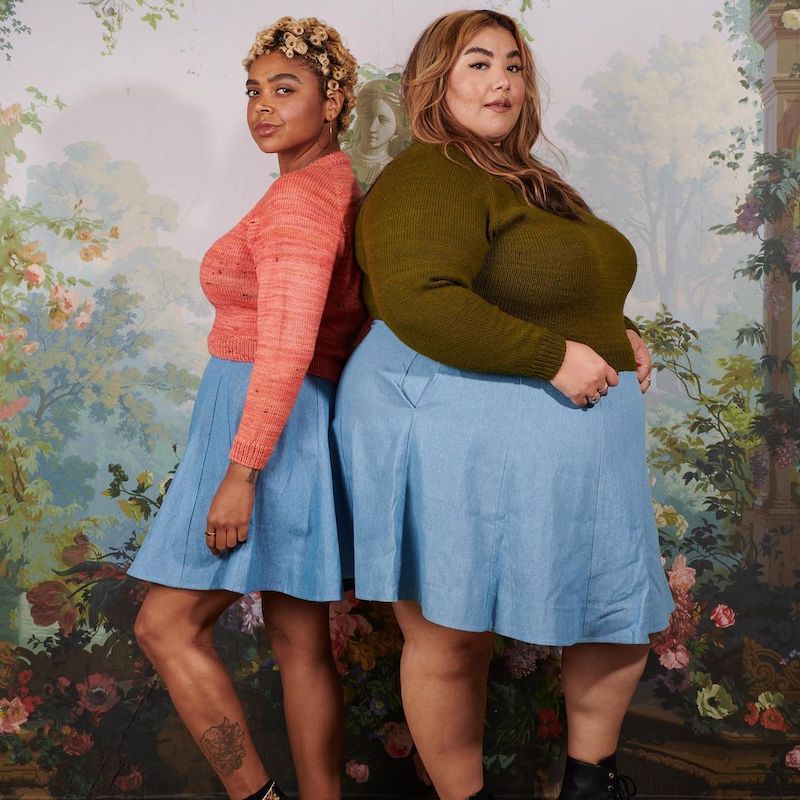 a thin woman and a fat woman standing back to back wearing the same style of short blue skirt